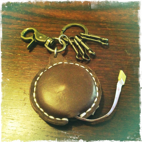 Leather key fob with metal decoration and tape measure