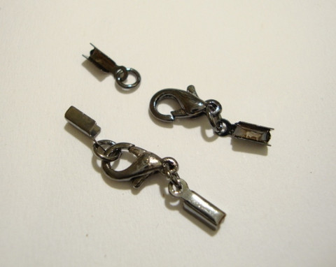 Nauhanpää 1-2 mm nauhalle, liimattava + rapulukko 10 mm musta (5/pss)