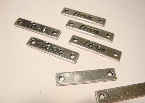 Korulinkki / riipus Love hopeoitu 6 x 25 mm, reikien halkaisija n. 2 mm (4 kpl/pss)
