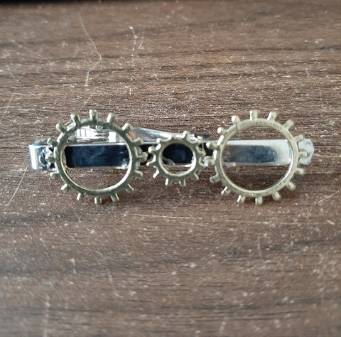 Silver-colored steampunk tie clip with gears.