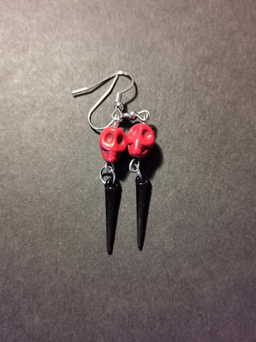 Black coloured spike earrings with red skull