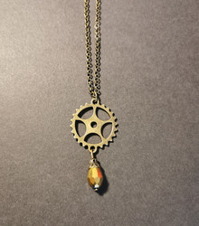 Gear necklace with gold colored drop