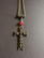 Cross with skulls necklace with red beads