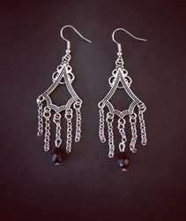 Hanging Earrings with chains and black droplets.